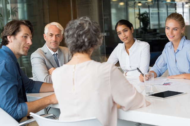 a group of professionals sitting around a table in discussion.